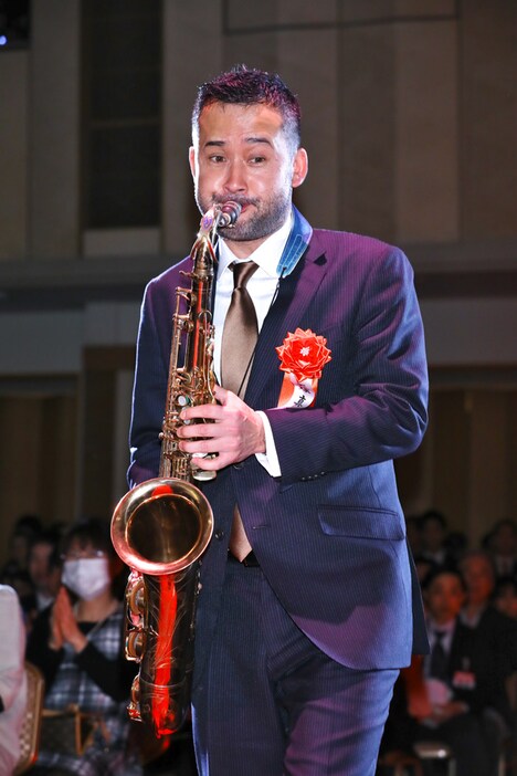 サックスを吹きながら登場した石塚真一。