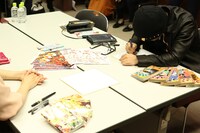 青山剛昌と末次由紀によるコラボイラストの執筆の様子。