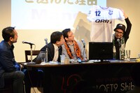 「サポルト！」のグッズのひとつ・ユニフォームを紹介する高田桂。