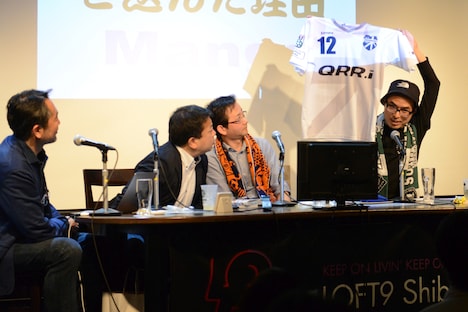 「サポルト！」のグッズのひとつ・ユニフォームを紹介する高田桂。