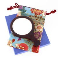 「たたりちゃん手鏡」と、付属の巾着。巾着は手縫いなのでデザインは変更される。