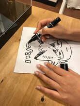 「春風のエトランゼ展～紀伊カンナの世界～」で展示される色紙の制作風景。