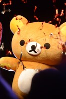 キャノン砲から放たれた銀テープ越しに見るリラックマ。