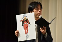 シャア・アズナブルのボードを掲げる藤井ペイジ。