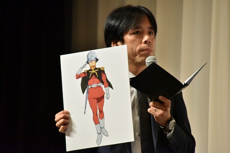 シャア・アズナブルのボードを掲げる藤井ペイジ。