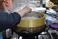 火の通り具合を竹串で確認するきくち夫人。