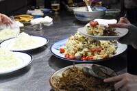 ポテトサラダときんぴらごぼうを、思い思いに盛り付ける来場者。