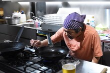 フライパンを火にかけるきくち正太。