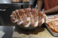 タレの汁気を落とすため、ボウルの縁に並べられた豚肉。