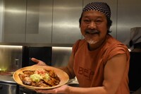 豚の生姜焼きを持ったきくち正太。