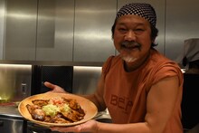 豚の生姜焼きを持ったきくち正太。