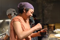 里芋に火が通ったか確認するきくち正太。