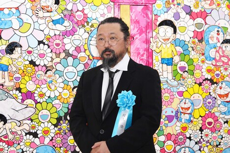 自身の作品「あんなこといいな 出来たらいいな」の前に立つ村上隆。