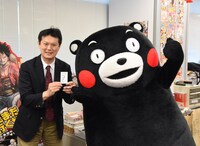 中野博之編集長と名刺交換をするくまモン。