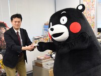 中野博之編集長と名刺交換をするくまモン。