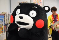 中野博之編集長の名刺を手にするくまモン。