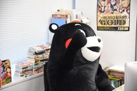 中野博之編集長のデスクに座り編集長気分を味わうくまモン。