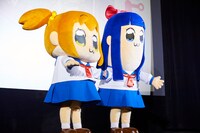 ポプ子とピピ美の着ぐるみ。花束を渡すために片方の手はむき出しである。