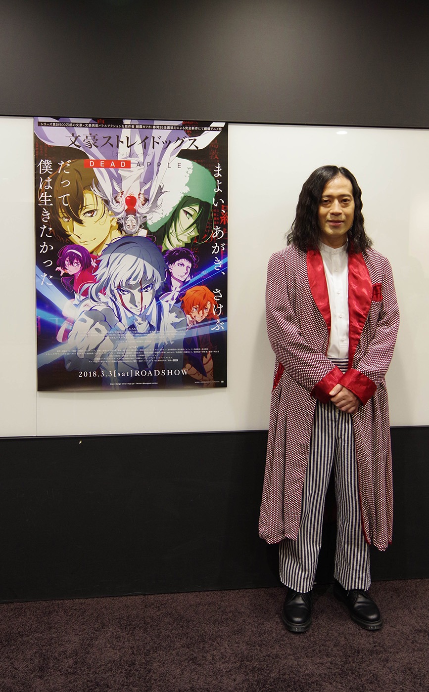 「文豪ストレイドッグス DEAD APPLE」ポスターと並ぶ宣伝隊長の又吉直樹。