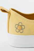 巴マミモデルのスニーカー。