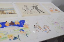 「くらもちふさこ・いくえみ綾二人展『“あたしの好きな人”へ』」より、「『天然コケッコー』の部屋」コーナーの様子。台に並べられた原画は、とても近くで細かい部分まで見ることができる。