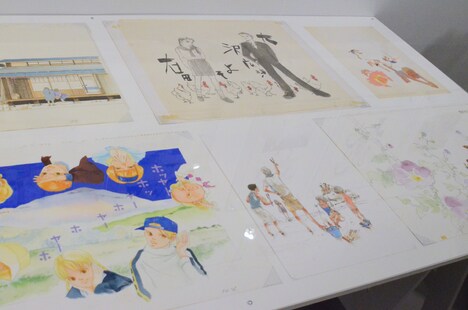 「くらもちふさこ・いくえみ綾二人展『“あたしの好きな人”へ』」より、「『天然コケッコー』の部屋」コーナーの様子。台に並べられた原画は、とても近くで細かい部分まで見ることができる。