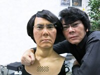 石黒に酷似した遠隔操作型アンドロイド・ジェミノイドHI-5と、石黒浩。