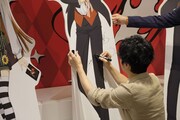 キャラクターパネルにサインをする福山潤。