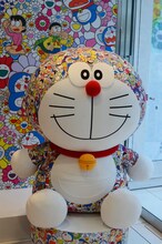 村上隆のアートワークを落とし込んだ、ドラえもんの巨大ぬいぐるみ。