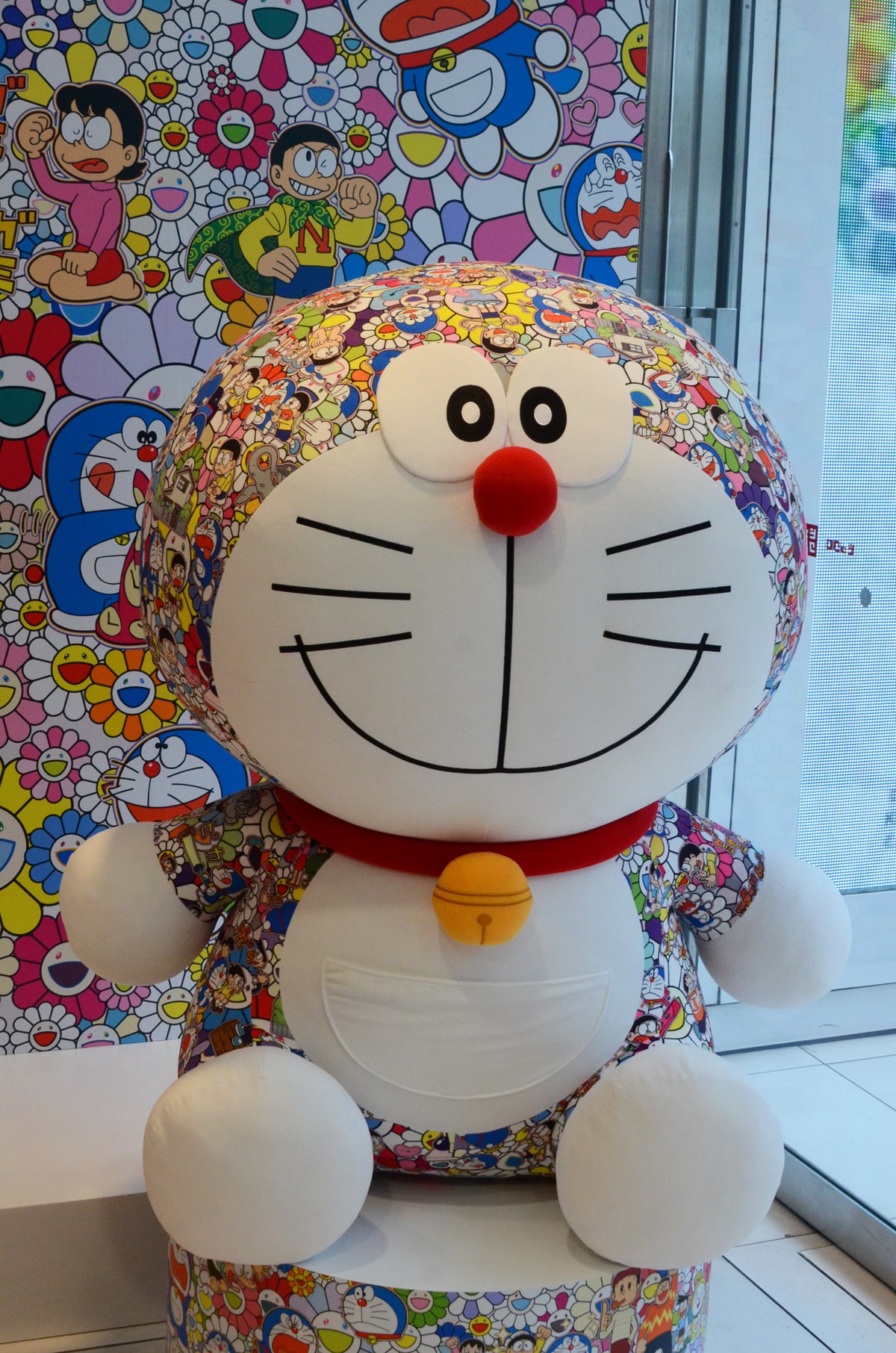 村上隆のアートワークを落とし込んだ、ドラえもんの巨大ぬいぐるみ 