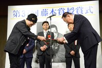 賞状を受け取る青山剛昌（左）。