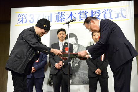 賞状を受け取る青山剛昌(左)。