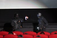 「影鰐 LIVE 上映 2.8 猿楽ナイトツアー」の様子。乱入した特殊部隊が、コラボドリンクの奇獣化予防効果をアピールする。