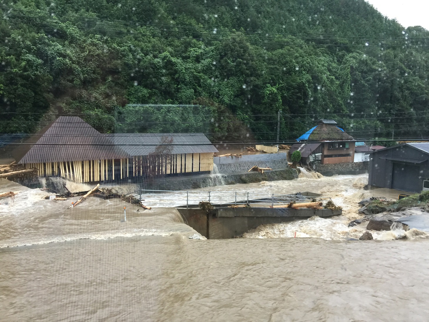 旭酒造前の川が氾濫したため、酒造への浸水、送電線の破断などの被害が出た。 提供／旭酒造