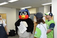 金城からのインタビューを受けるつば九郎とまがりひろあき。