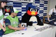 単行本にサインを入れるまがりひろあきとつば九郎。