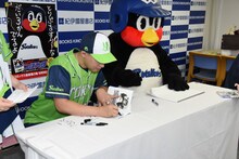 単行本にサインを入れるまがりひろあきとつば九郎。