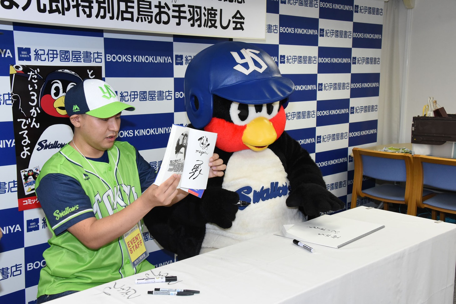 単行本にサインを入れるまがりひろあきとつば九郎。