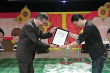 「ハッピーサマーバレンタインデー」の記念日登録証を受け取る許斐剛（右）。