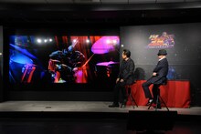 MVでドラムを叩くラオウを見つめる原哲夫、武論尊。