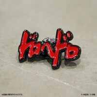 「ドロヘドロ」ロゴのピンバッジ（赤）。