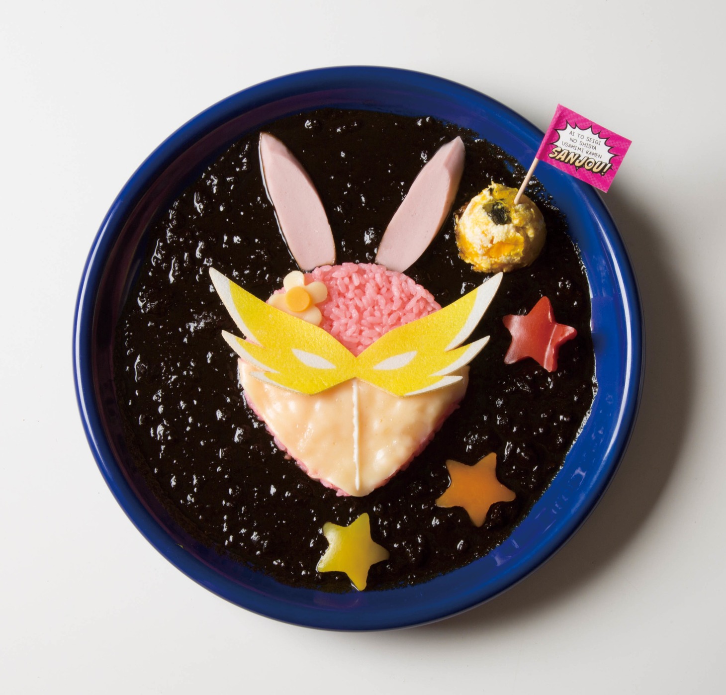 「ウサミミ仮面のダークパワーカレー」は、ウサミミ仮面の顔面がブラックカレーの闇から浮かび上がる一品。