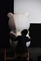 新田将司に支えられながらステージへと上がるシロートくん。