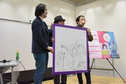 藤沢とおると山田貴敏合作によるイラストボード。客席に登場した藤田和日郎に話しかける山田貴敏（右）。