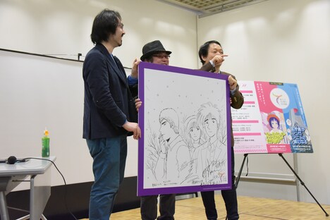 藤沢とおると山田貴敏合作によるイラストボード。客席に登場した藤田和日郎に話しかける山田貴敏（右）。