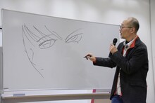 アニメと原作のしろがねの目の違いを描く藤田和日郎。隣では「違いを描いてみてよ」と振った島本和彦が、iPadでアニメのしろがねの画像をこっそりと観客に見せていた。