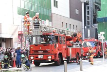 はしご車に乗る梶原岳人（左）。