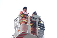 はしご車に乗る梶原岳人（左）。