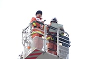 はしご車に乗る梶原岳人(左)。
