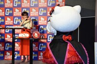 高橋愛（奥）とハートを送り合うハローキティ（手前）。